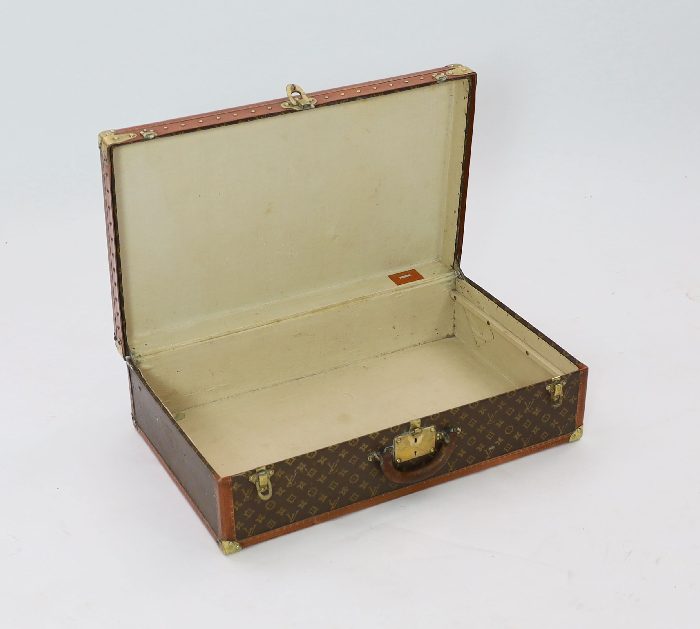 A Louis Vuitton brass mounted leather bound suitcase, 76 x 46cm depth 22cm